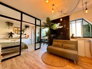 a living room with a couch and a bedroom at Splendide Loft avec Jacuzzi et Cinema - Cap d'Agde in Agde