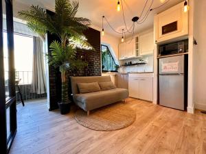 a living room with a couch and a kitchen at Splendide Loft avec Jacuzzi et Cinema - Cap d'Agde in Agde