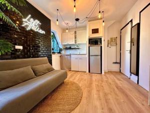 a living room with a couch and a kitchen at Splendide Loft avec Jacuzzi et Cinema - Cap d'Agde in Agde +27 photos