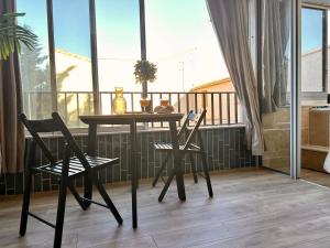 a table and two chairs on a balcony at Splendide Loft avec Jacuzzi et Cinema - Cap d'Agde in Agde