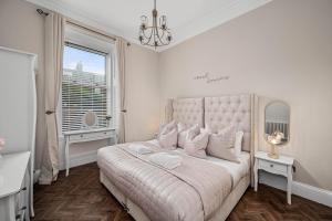 a white bedroom with a large bed and a window at Willowbank in Broughty Ferry