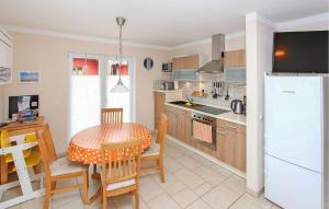 a kitchen with a table and a white refrigerator at Ferienwohnung Bodstedt in Bodstedt