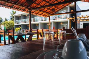 a table in a restaurant with a view of a building at Pousada Pé na Areia in São Miguel dos Milagres +23 photos