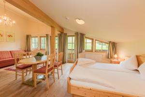 una camera da letto con un letto, un tavolo e un divano di Berggasthof Christernreith a Maria Alm am Steinernen Meer