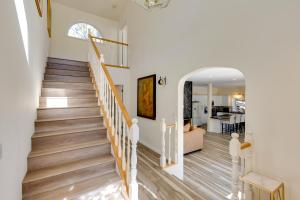 una escalera en una casa con paredes blancas y suelo de madera en Game Room and Deck Modern Frazier Park Home!, en Pine Mountain Club