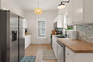 a kitchen with white cabinets and a stainless steel refrigerator at Odie's Oasis on Union in Brunswick