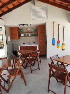 a kitchen with wooden tables and chairs and vases on the wall at Apartamento pé na areia in Ubatuba