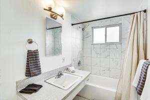 a white bathroom with a sink and a shower at 3 Mi to Balboa Park Water-View Condo with Balcony in San Diego +18 photos
