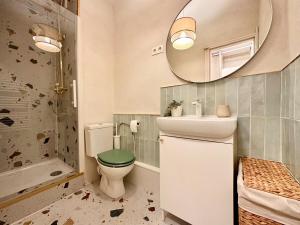 ein Badezimmer mit Toilette, Waschbecken und Spiegel in der Unterkunft Mini Loft avec Cinema et Terrasse - Cap D'Agde in Cap d'Agde + 22 Fotos