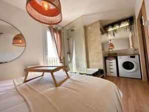 a bedroom with a bed with a table on it at Exceptionnel Appartement avec Cinema - Cap d'Agde in Agde