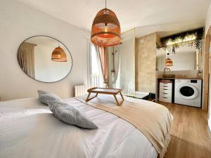 a bedroom with a white bed with a table on it at Exceptionnel Appartement avec Cinema - Cap d'Agde in Agde
