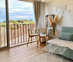 a living room with a table and chairs and a balcony at Exceptionnel Appartement avec Cinema - Cap d'Agde in Agde