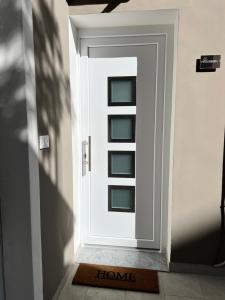 una porta bianca con un tappetino di benvenuto davanti di Amira Guest House a Catania