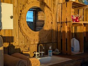 a bathroom with a mirror and a sink at La Window Glamping in La Ventana