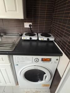 a kitchen with a washing machine in a kitchen at The Peacock studio 7 mins from Luton airport in Luton