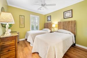 two beds in a room with green walls at 53B Blue Wedge at True Blue condo by Peace Vacations in Pawleys Island