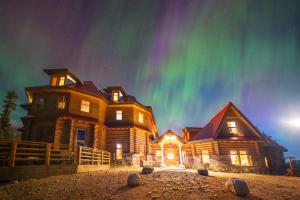 una gran casa de madera con la aurora en el cielo en The Lodge at Bow Lake, en Lago Louise