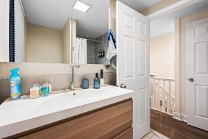 a bathroom with a sink and a mirror at Spacious 3-Bedroom Apt in the Heart of Philly in Philadelphia +32 photos