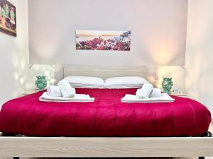 a bedroom with a red bed with towels on it at Seacily house in Mazara del Vallo