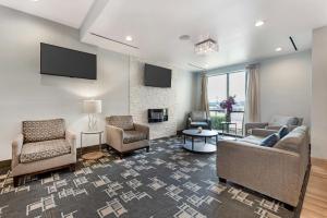 a living room with couches and chairs and a tv at Best Western Plus Buda Austin Inn & Suites in Buda