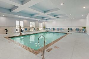 a large swimming pool in a building with blue ceilings at Best Western Plus Buda Austin Inn & Suites in Buda