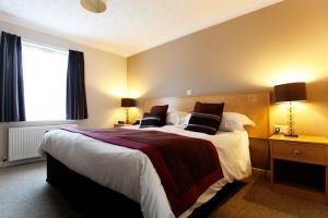 a bedroom with a large bed and a window at Anchorage Hotel & Spa in Torquay