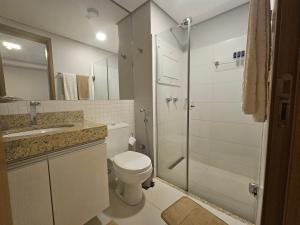 a bathroom with a toilet and a shower and a sink at Hotel Flat Afonso Pena in Campo Grande