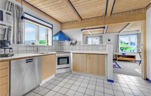 una grande cucina con soffitti in legno e una grande finestra di Three-Bedroom Holiday Home In Bagenkop a Bagenkop Altre 24 foto