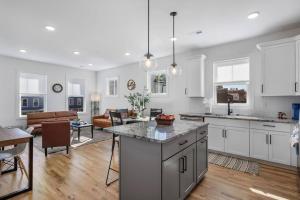 a kitchen with white cabinets and a living room at Duplex with Balcony and Spacious Dog-Friendly Oasis! in Richmond