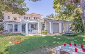 a large white house with a yard with a table at Lovely Home In Málaga in Málaga