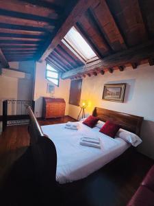 a bedroom with a large bed with white sheets and red pillows at Palazzo Duomo in Verona