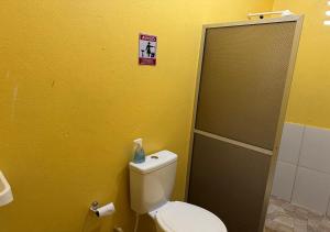 a bathroom with a toilet and a sign on the wall at Casa Amarela in Presidente Figueiredo +16 photos