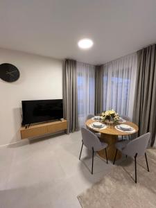 a living room with a table and a television at TM APARTMENTS Ludwiki in Warsaw