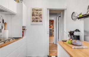 a kitchen with white cabinets and a wooden counter top at Stunning Apartment In København Sv in Copenhagen +10 photos