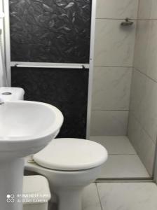 a bathroom with a toilet and a sink and a shower at Pousada Areia da Praia in Fortaleza