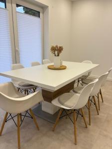 a dining room with a white table and chairs at Ferienwohnung Room of Grace in Bad Hersfeld +4 photos