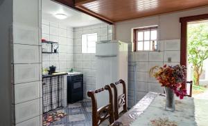 a kitchen with a table and a refrigerator at Sobrado da Prainha in Tiradentes