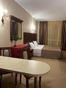 ポモリエにあるPrivate room Festa Pomorieのベッドとテーブルのあるホテルの部屋
