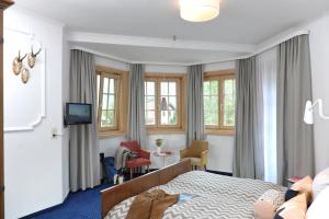 ein Hotelzimmer mit Bett, Tisch und Stühlen in der Unterkunft Alpenrose Bayrischzell Hotel in Bayrischzell