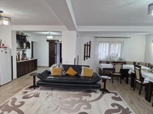 a living room with a black couch and a table at Casa Catinca in Moldoviţa