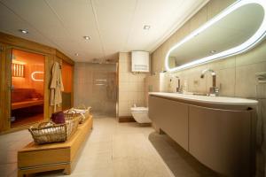 un bagno con lavandino, WC e specchio di Appartement de prestige dans chalet Novalsia à Méribel avec sauna a Méribel Altre 15 foto