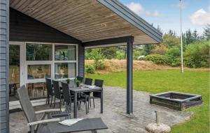 un patio con tavolo, sedie e braciere di Holiday Home Hovgårdsvej Henne Iii a Henne Strand