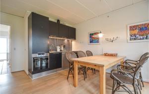 Una cocina y un comedor con mesa y sillas de madera. en Lejlighed 28, en Rømø Kirkeby