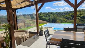 a patio with a table and chairs and a swimming pool at Villa Baročka Holiday Home in Štrigova