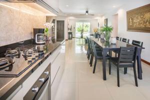 a large kitchen with a long table and chairs at Villa Waleree in Pattaya South