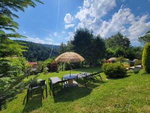 a group of tables and chairs with an umbrella at Chatka Beskidzka in Targanice