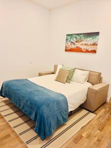 ポルトにあるBright apartment with gardenのベッドと壁に絵が飾られた寝室