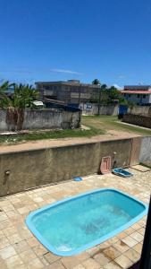 a small swimming pool on a patio with a pink chair at casa ilha de itamaraca in Itamaracá