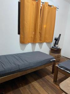 a bench in a room with yellow curtains at casa ilha de itamaraca in Itamaracá