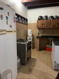 a kitchen with a stove and a refrigerator at casa ilha de itamaraca in Itamaracá +1 photo